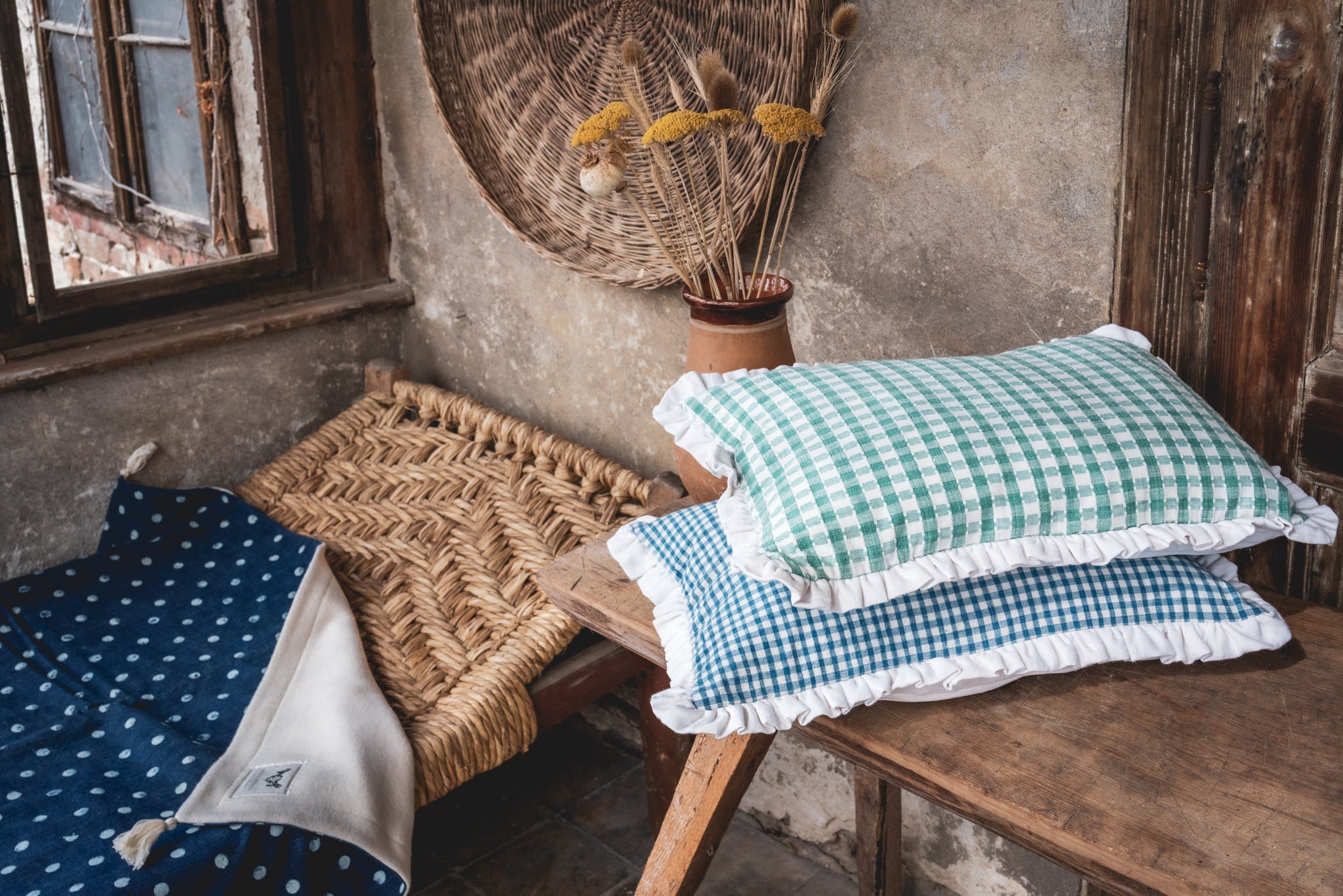 Antique handwoven decorative pillows with Bulgarian cotton on rustic wooden bench.