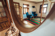 Antique handwoven felted rug from Bulgaria in a rustic room setting with blue chairs.