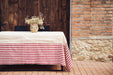 Antique handwoven hemp tablecloth with Bulgarian cotton border on outdoor table with floral centerpiece