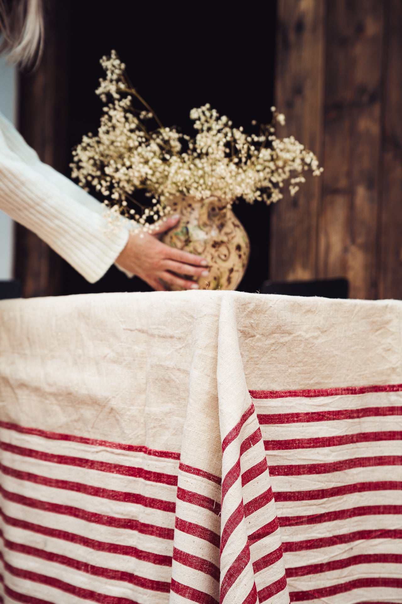 Antique handwoven hemp tablecloth with red striped Bulgarian cotton border on wooden table
