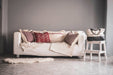 Handwoven antique Hungarian hemp pillows on a white sofa in a cozy living room setting.