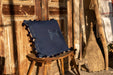 Handwoven antique Hungarian indigo hemp pillow with wax resist pattern on wooden chair.