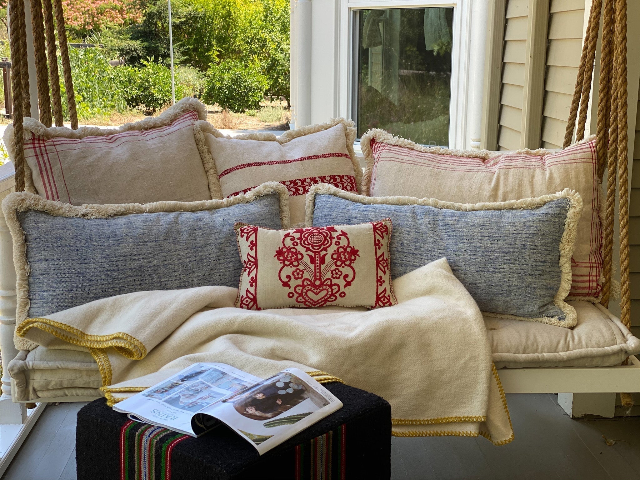 Handwoven hemp cloth pillows and throw on a cozy swing, showcasing rustic charm and eco-friendly design.