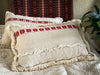 Handwoven antique Hungarian hemp pillow with red carnation pattern and cotton fringe.