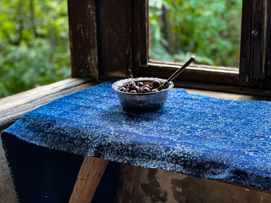 Antique handwoven Hungarian hemp table runner with indigo over dye, styled with a bowl of cherries.