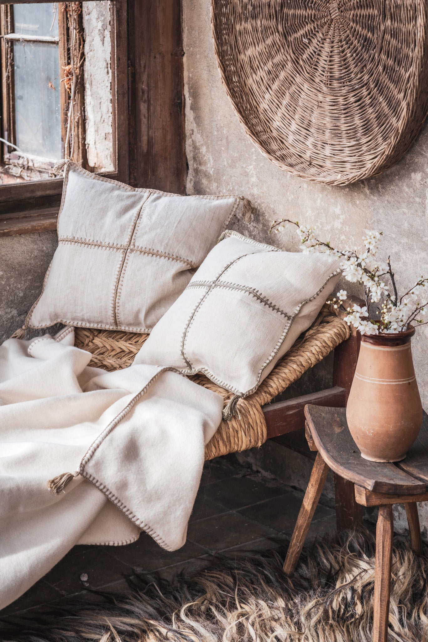 Antique Hungarian handwoven hemp pillow with hand stitching on rustic chair.