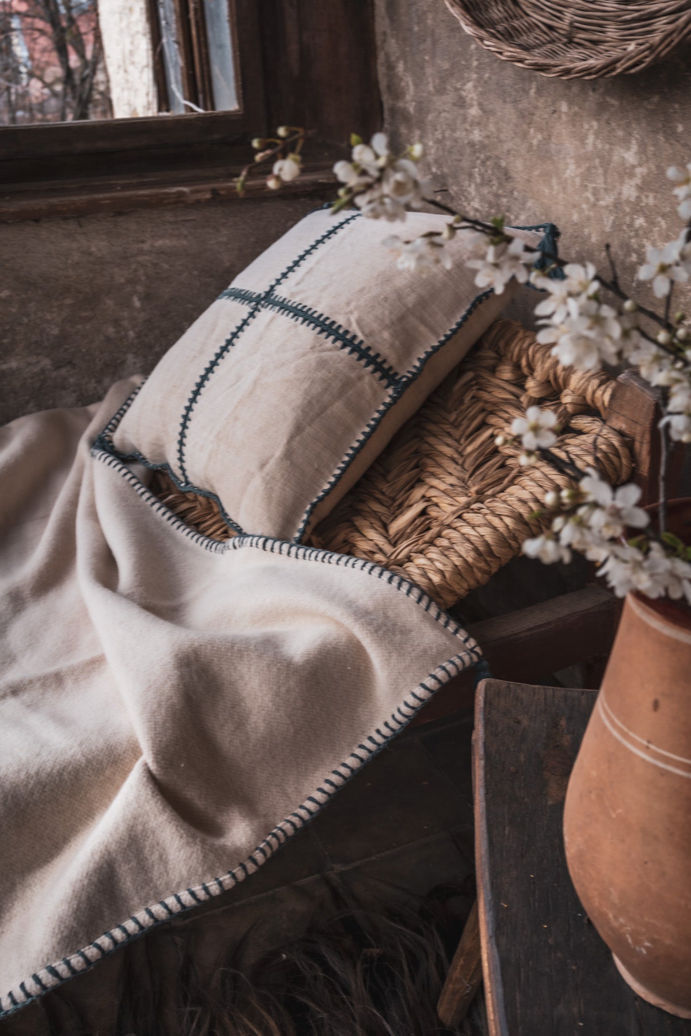 Antique Hungarian handwoven hemp pillow with hand stitching on rustic chair.