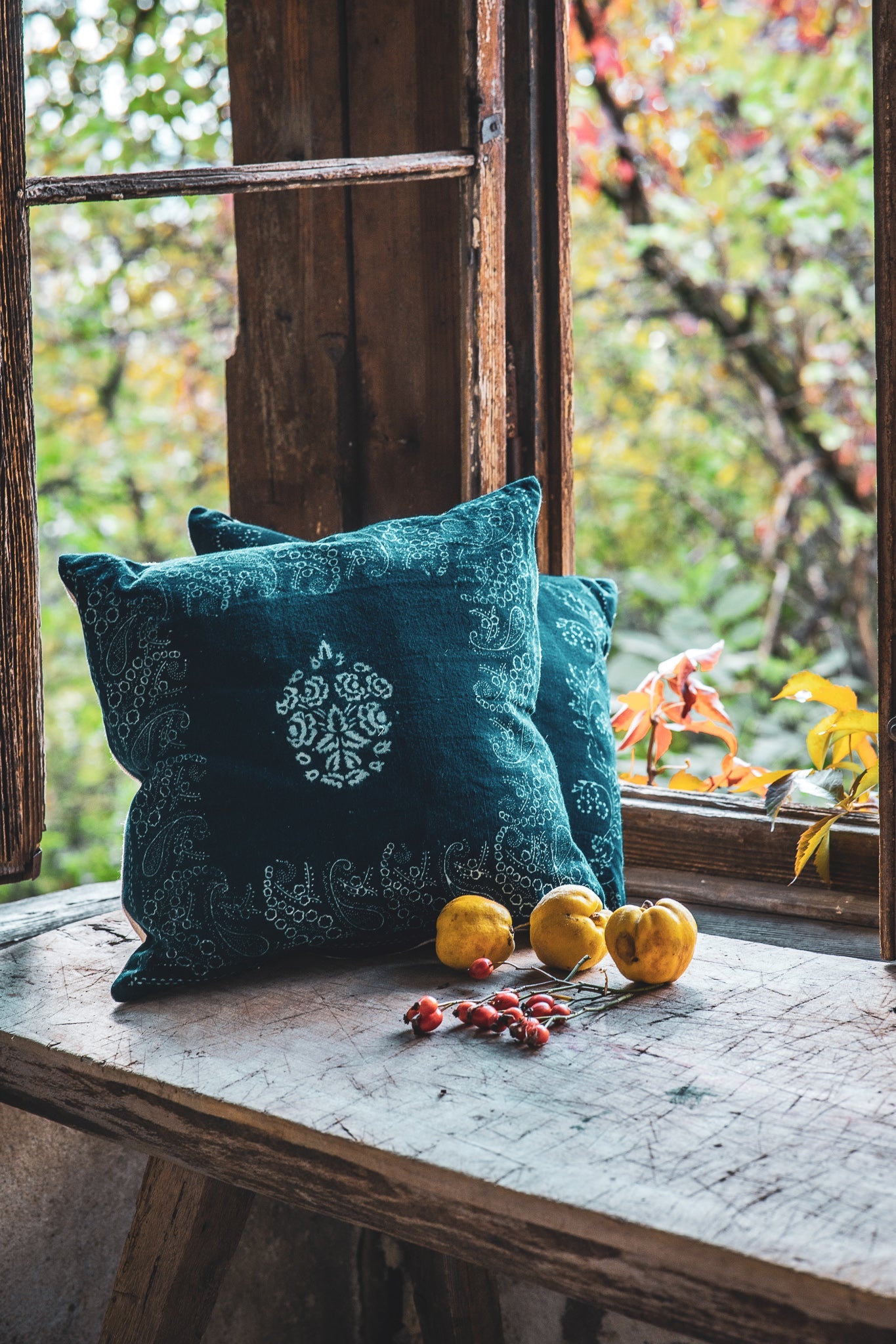 Handwoven antique Hungarian hemp pillow with indigo wax resist dye, displayed on a rustic windowsill.