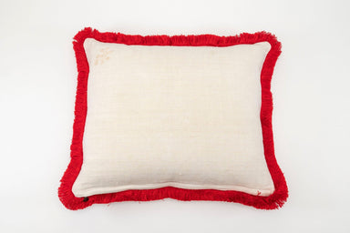 Embroidered antique handwoven Hungarian hemp pillow with red fringe detailing.