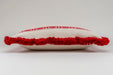 Embroidered antique handwoven Hungarian hemp pillow with red tassels.