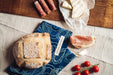 Handwoven antique bread bag with bread and cheese arrangement.