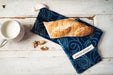 Handwoven antique hemp baguette bag with indigo dye and baguette bread.