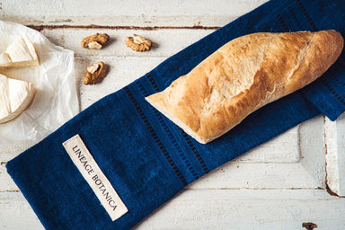 Handwoven antique and vintage hemp baguette bag with indigo dye by Tolnai Kekfesto, displaying bread and cheese.