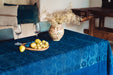 Antique handwoven Hungarian hemp table cloth with indigo dye and border design, styled with fruit and floral vase.