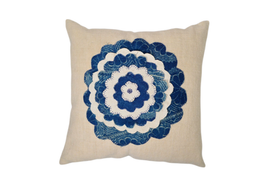 Antique handwoven decorative pillow with blue appliqué design.