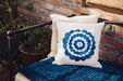 Antique handwoven decorative pillow with appliqué design on a bench.