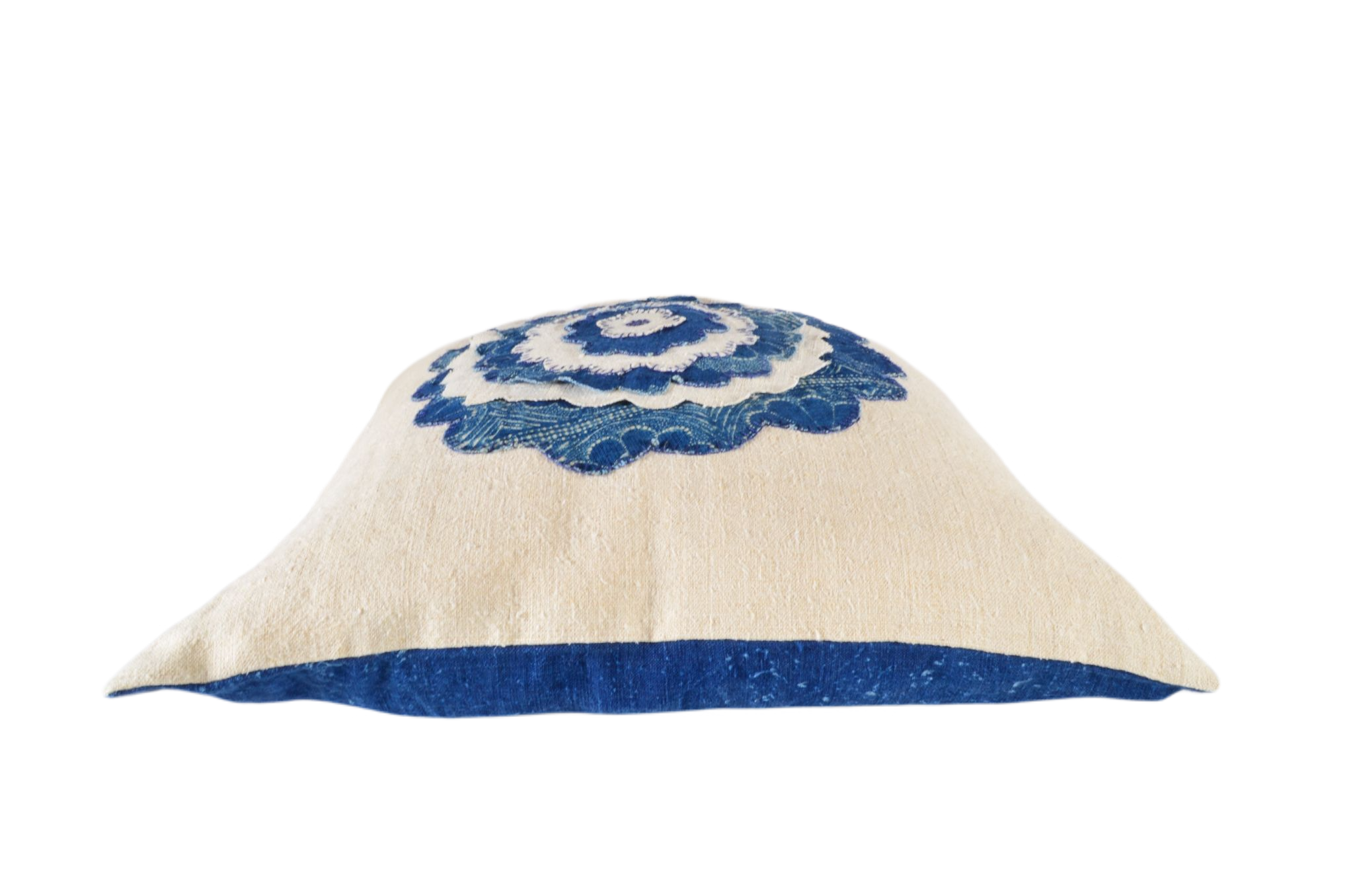 Antique handwoven decorative pillow with blue appliqué design.