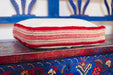 Antique handwoven decorative pillow with Bulgarian cotton edge on vibrant wooden surface.