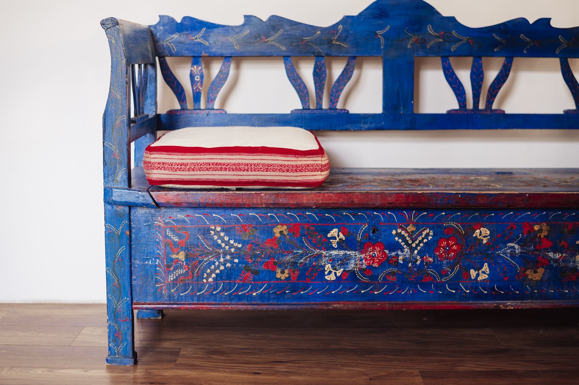 Antique handwoven decorative pillow with Bulgarian cotton edge on vintage bench.