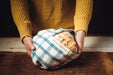 Antique handwoven Bulgarian cotton bag holding bread.