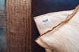 Eco-cotton throw with hand-stitched cinnamon trim, showcasing organic luxury.