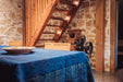 Antique handwoven Hungarian hemp table cloth with indigo over dye and yellow border pattern in rustic dining room.