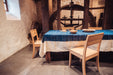 Antique handwoven Hungarian hemp table cloth with indigo over dye, displayed on a dining table.