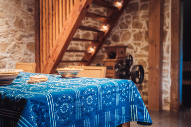 Antique handwoven Hungarian hemp table cloth with indigo wax resist design on dining table.