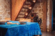 Antique Hungarian hemp table cloth with indigo wax resist design, displayed on wooden dining table.