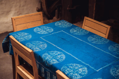 Antique Hungarian hemp table cloth with indigo wax resist design on wooden table.