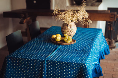 Antique handwoven Hungarian hemp table cloth with indigo wax resist dye, featuring dried flowers in a vase and fruits on a tray.